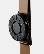 A photo of the watch from a side angle. The recessed track around the outside of the watch face is shown with the hour ball bearing in the track. The raised markers are noticeable from this perspective.