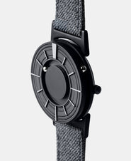 A photo of the watch from a side angle. The recessed track around the outside of the watch face is shown with the hour ball bearing in the track. The raised markers are noticeable from this perspective.