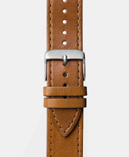 A photo shows the strap lying on a flat surface. One part has a buckle and the other part has a series of holes for an adjustable fit.