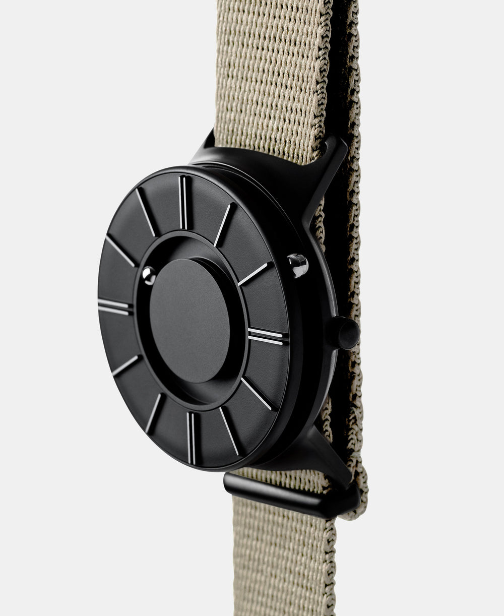 A photo of the watch from a side angle. The recessed track around the outside of the watch face is shown with the hour ball bearing in the track. The raised markers are noticeable from this perspective.