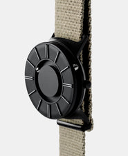 A photo of the watch from a side angle. The recessed track around the outside of the watch face is shown with the hour ball bearing in the track. The raised markers are noticeable from this perspective.