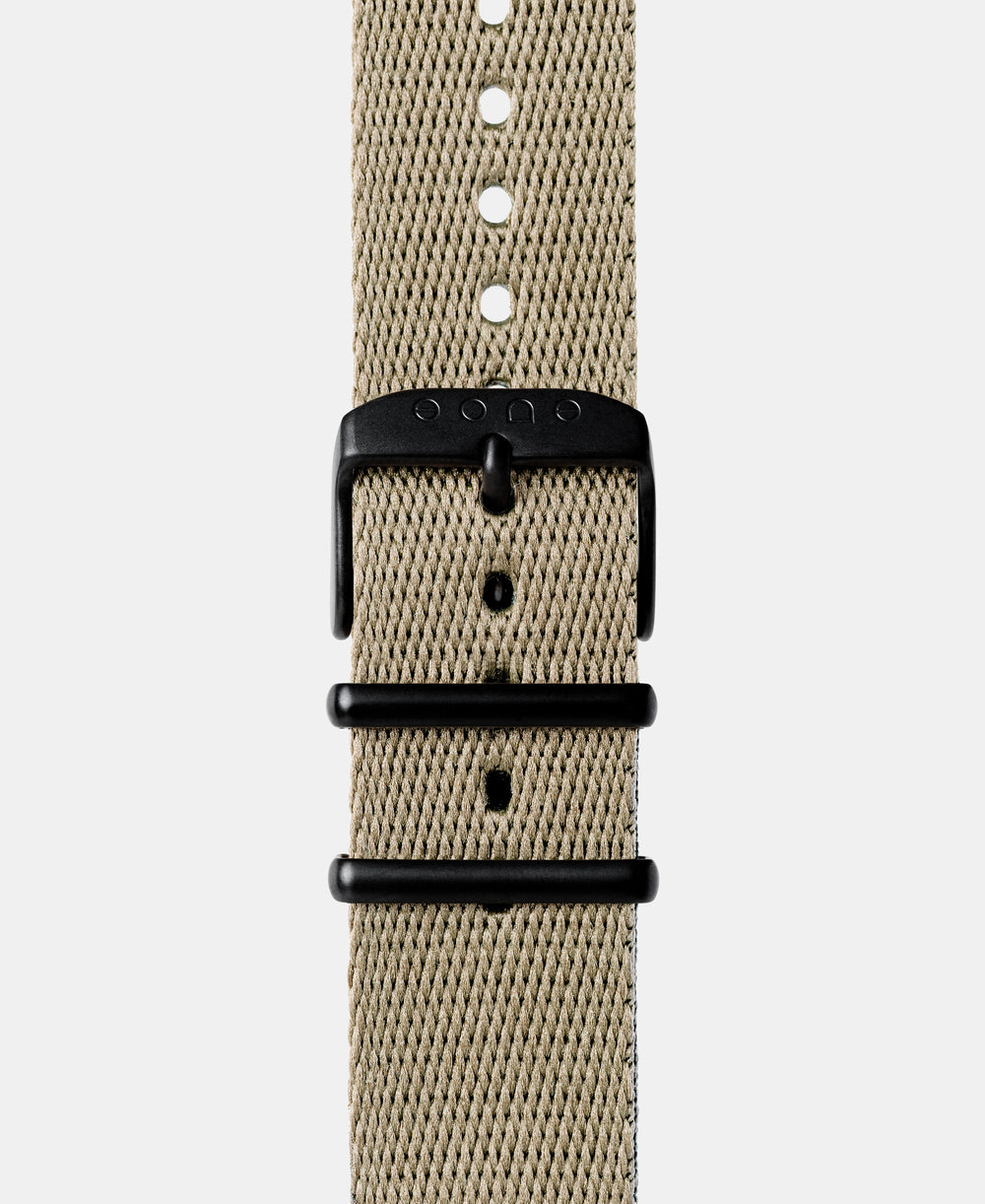 A photo shows the strap lying on a flat surface. One part has a buckle and the other part has a series of holes for an adjustable fit.