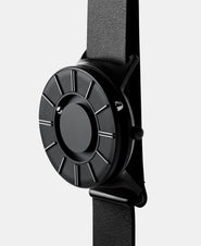 A photo of the watch from a side angle. The recessed track around the outside of the watch face is shown with the hour ball bearing in the track. The raised markers are noticeable from this perspective.