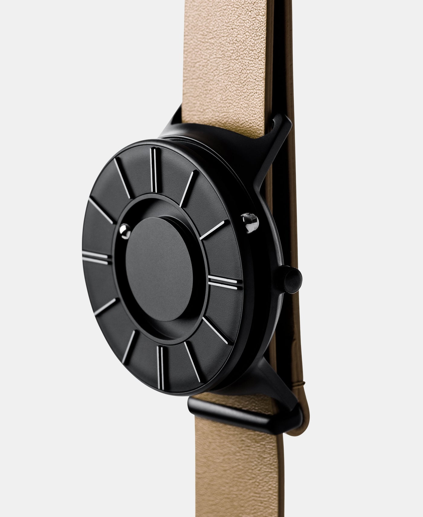 A photo of the watch from a side angle. The recessed track around the outside of the watch face is shown with the hour ball bearing in the track. The raised markers are noticeable from this perspective.