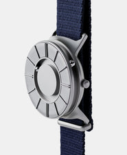 A photo of the watch from a side angle. The recessed track around the outside of the watch face is shown with the hour ball bearing in the track. The raised markers are noticeable from this perspective.