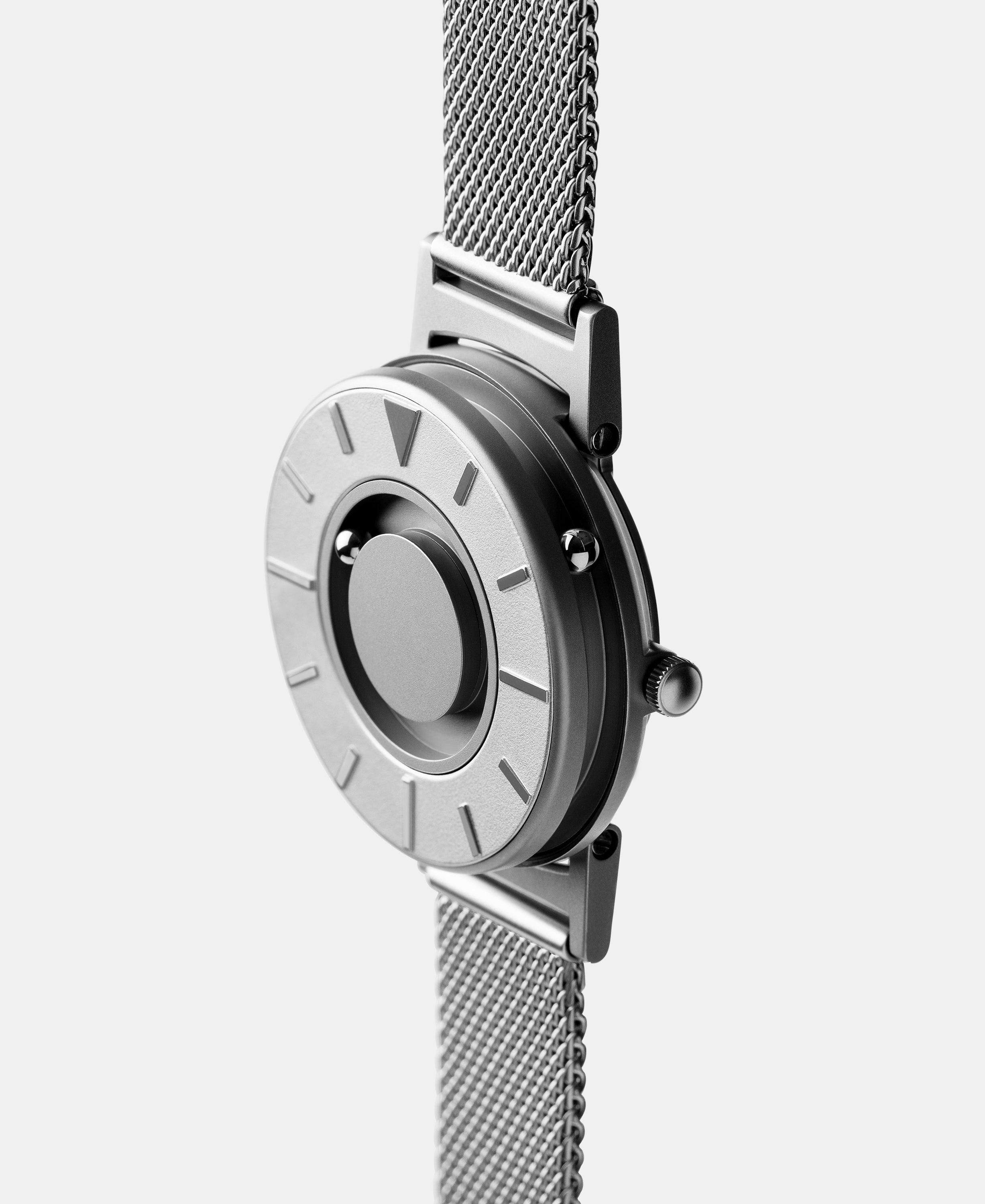 A photo of the watch from a side angle. The recessed track around the outside of the watch face is shown with the hour ball bearing in the track. The raised markers are noticeable from this perspective.