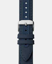 A photo shows the strap lying on a flat surface. One part has a buckle and the other part has a series of holes for an adjustable fit.