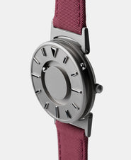 A photo of the watch from a side angle. The recessed track around the outside of the watch face is shown with the hour ball bearing in the track. The raised markers are noticeable from this perspective.