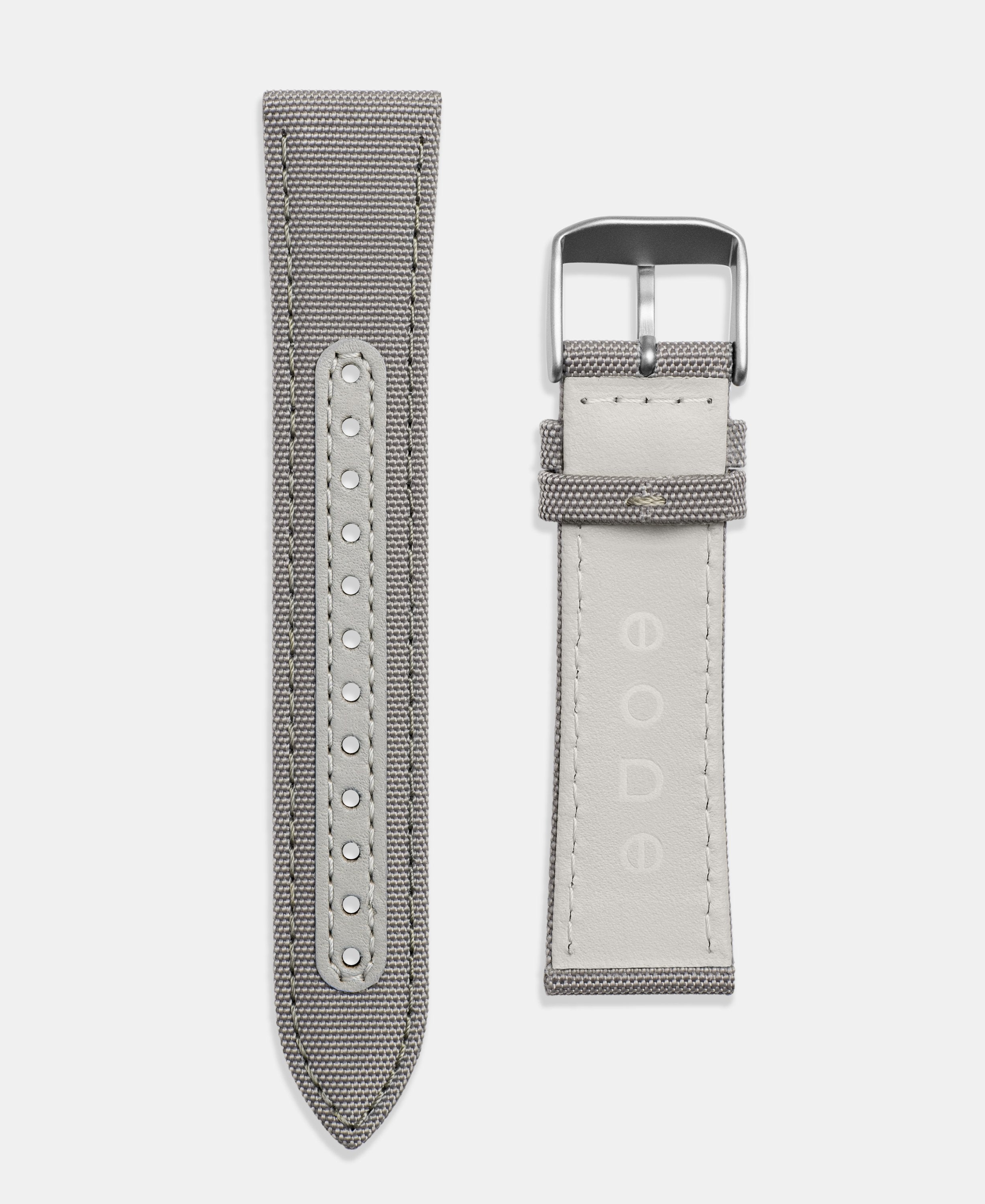 A photo shows the strap lying on a flat surface. One part has a buckle and the other part has a series of holes for an adjustable fit.