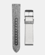 A photo shows the strap lying on a flat surface. One part has a buckle and the other part has a series of holes for an adjustable fit.