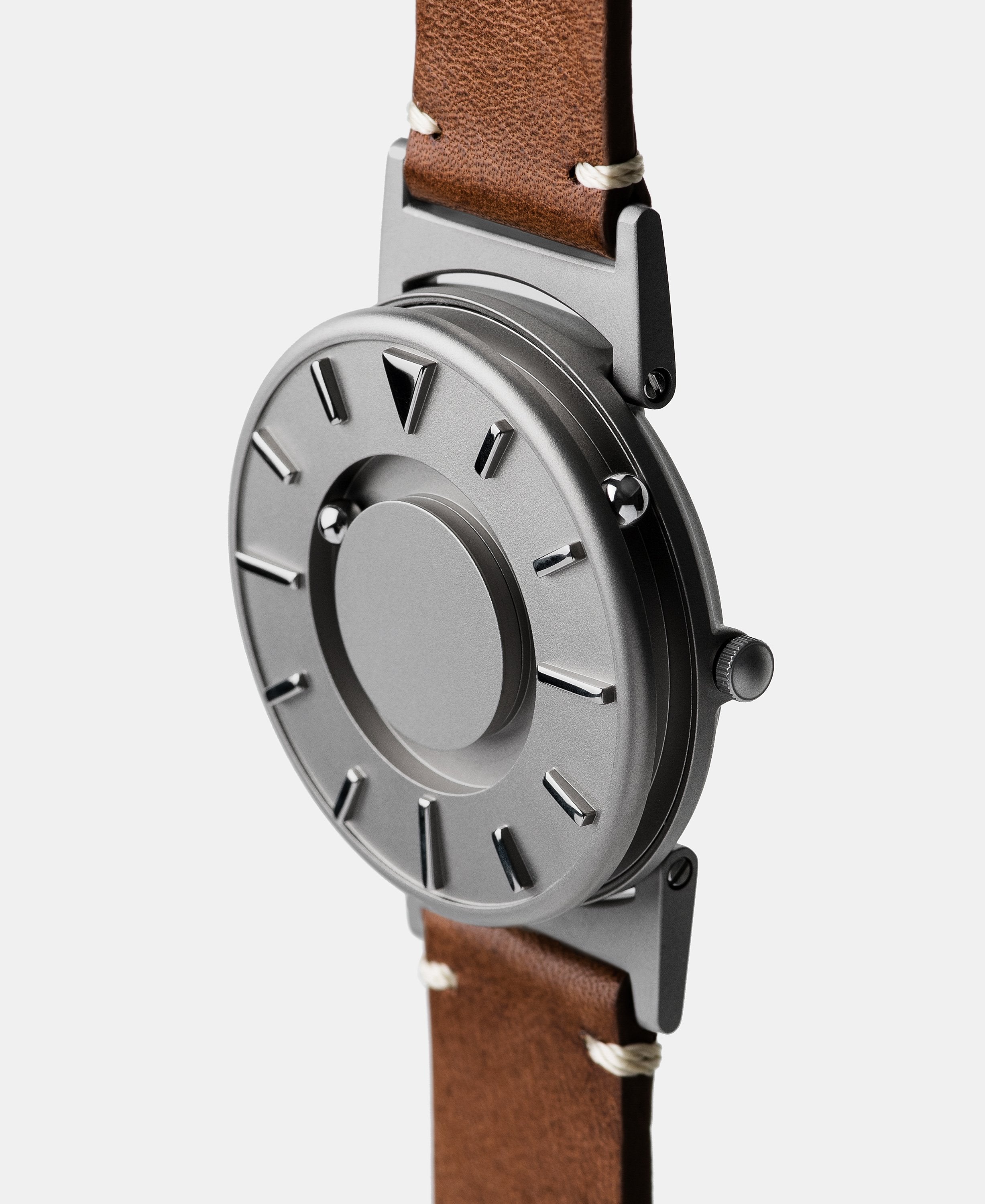 A photo of the watch from a side angle. The recessed track around the outside of the watch face is shown with the hour ball bearing in the track. The raised markers are noticeable from this perspective.