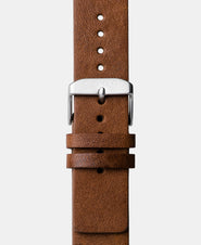 A photo shows the strap lying on a flat surface. One part has a buckle and the other part has a series of holes for an adjustable fit.