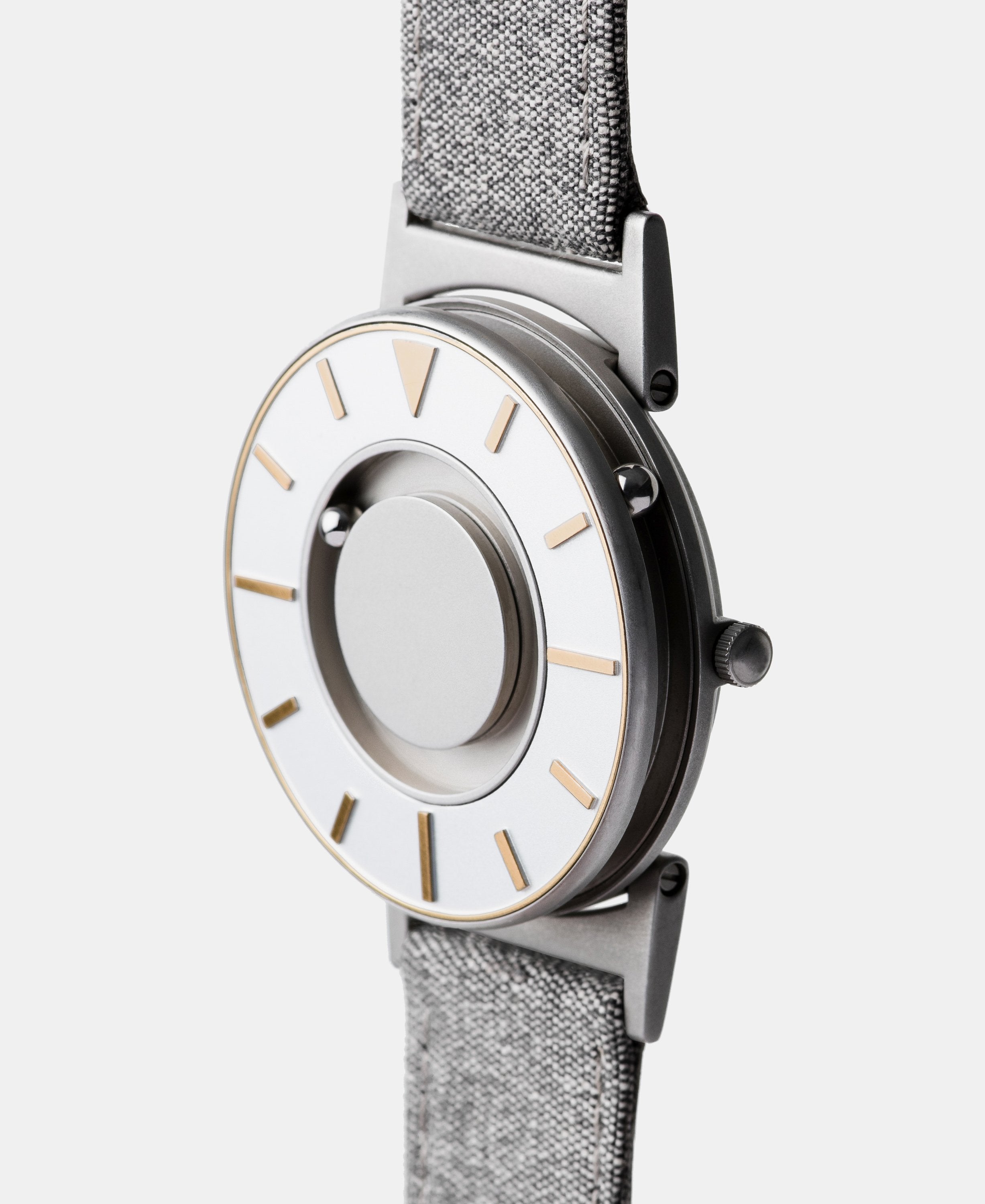 A photo of the watch from a side angle. The recessed track around the outside of the watch face is shown with the hour ball bearing in the track. The raised markers are noticeable from this perspective.