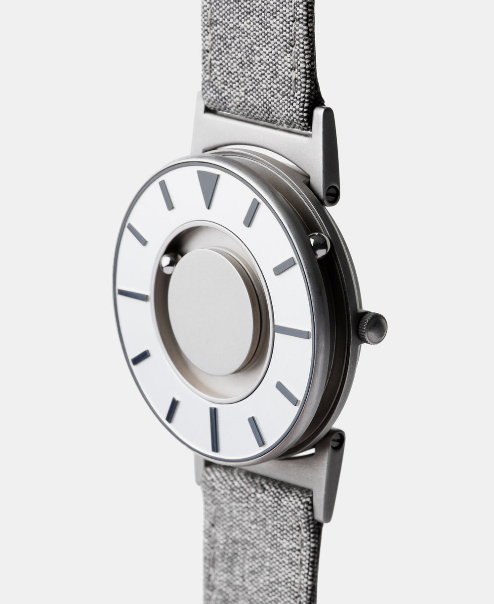 A photo of the watch from a side angle. The recessed track around the outside of the watch face is shown with the hour ball bearing in the track. The raised markers are noticeable from this perspective.