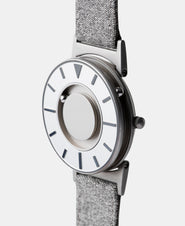 A photo of the watch from a side angle. The recessed track around the outside of the watch face is shown with the hour ball bearing in the track. The raised markers are noticeable from this perspective.