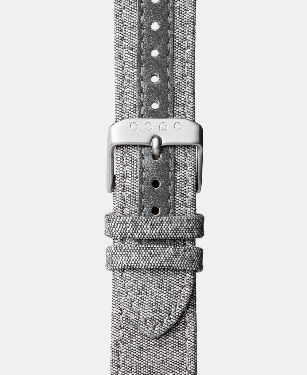 A photo shows the strap lying on a flat surface. One part has a buckle and the other part has a series of holes for an adjustable fit.