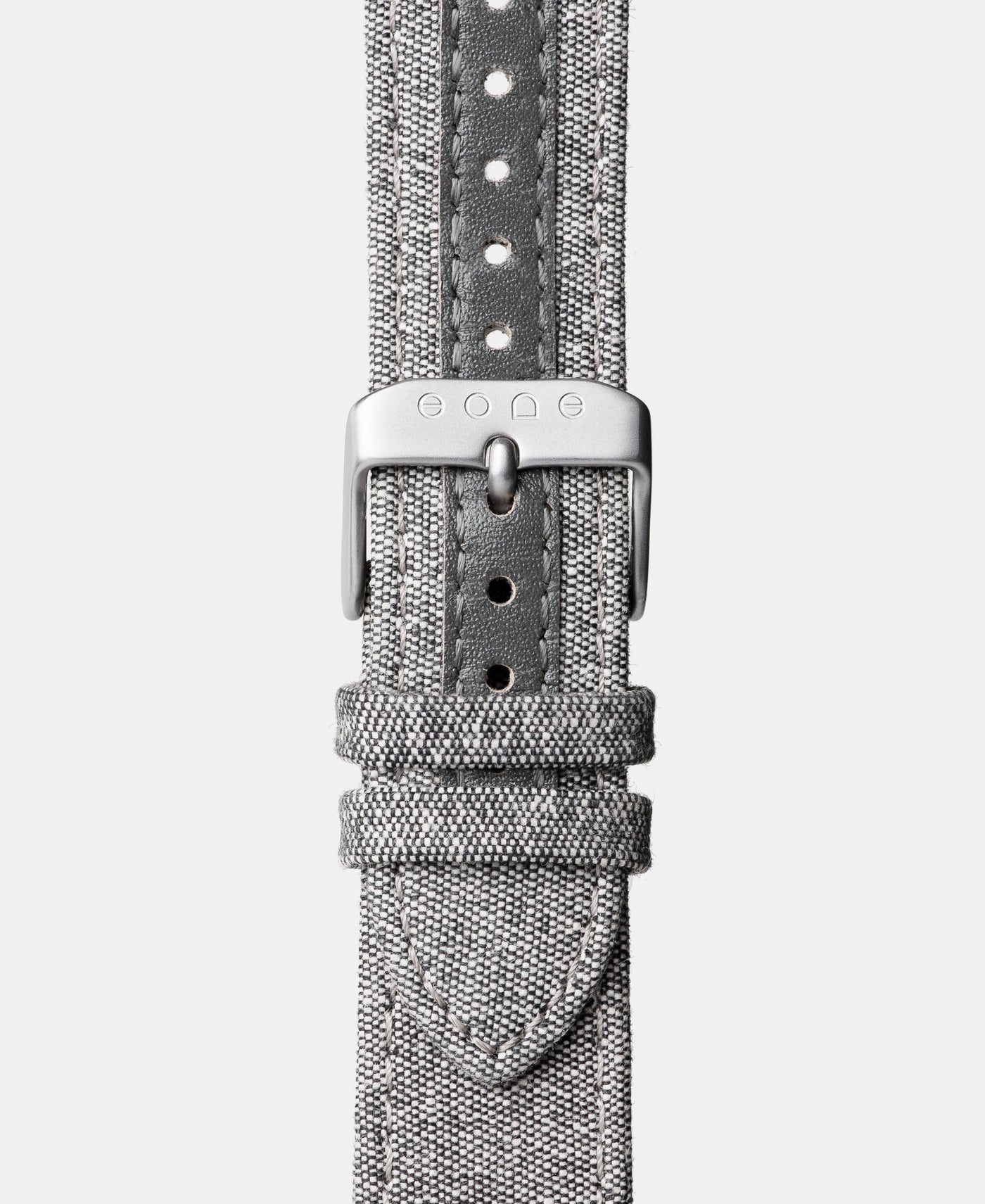 A photo shows the strap lying on a flat surface. One part has a buckle and the other part has a series of holes for an adjustable fit.