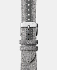 A photo shows the strap lying on a flat surface. One part has a buckle and the other part has a series of holes for an adjustable fit.