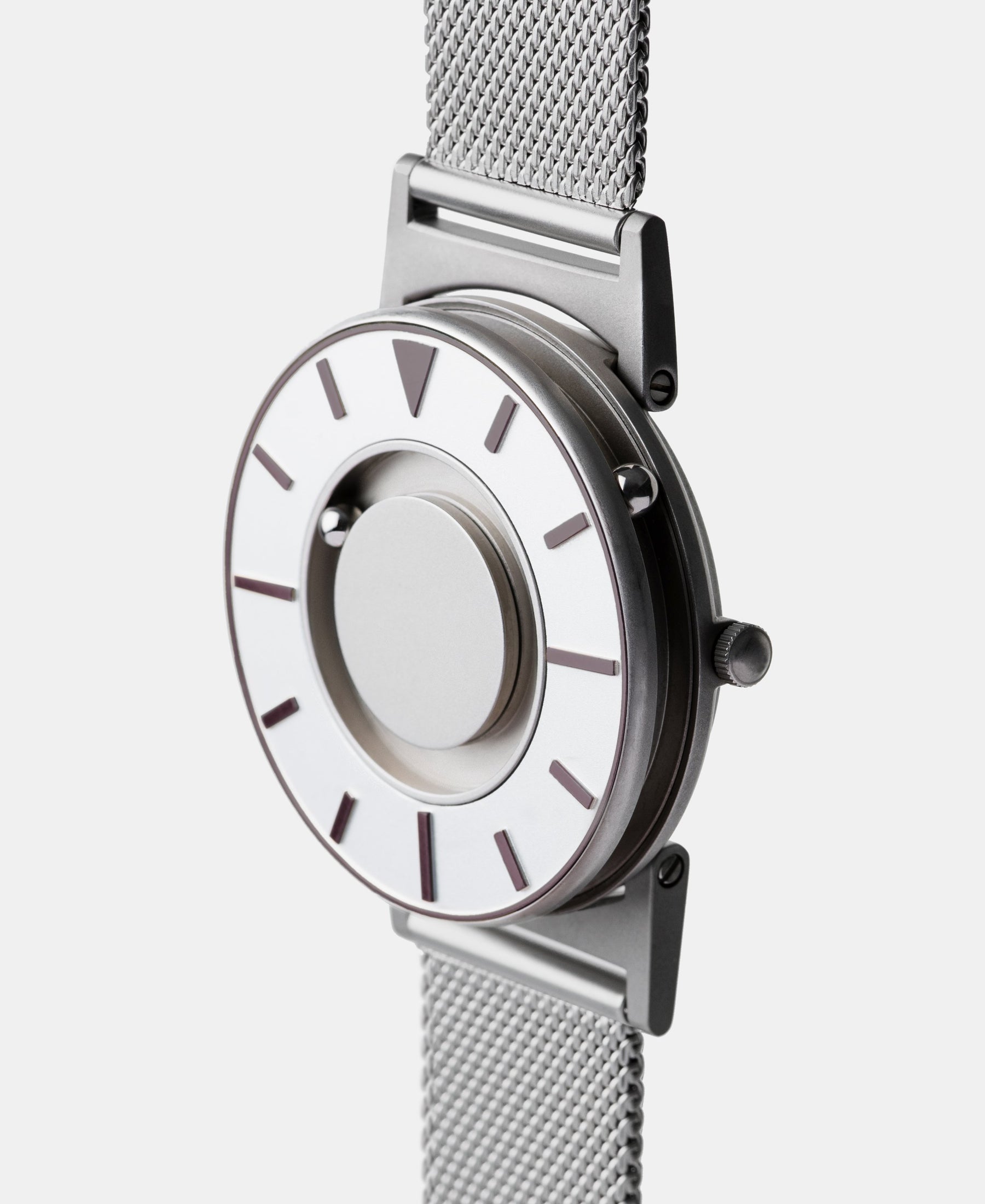 Load image into Gallery viewer, A photo of the watch from a side angle. The recessed track around the outside of the watch face is shown with the hour ball bearing in the track. The raised markers are noticeable from this perspective.