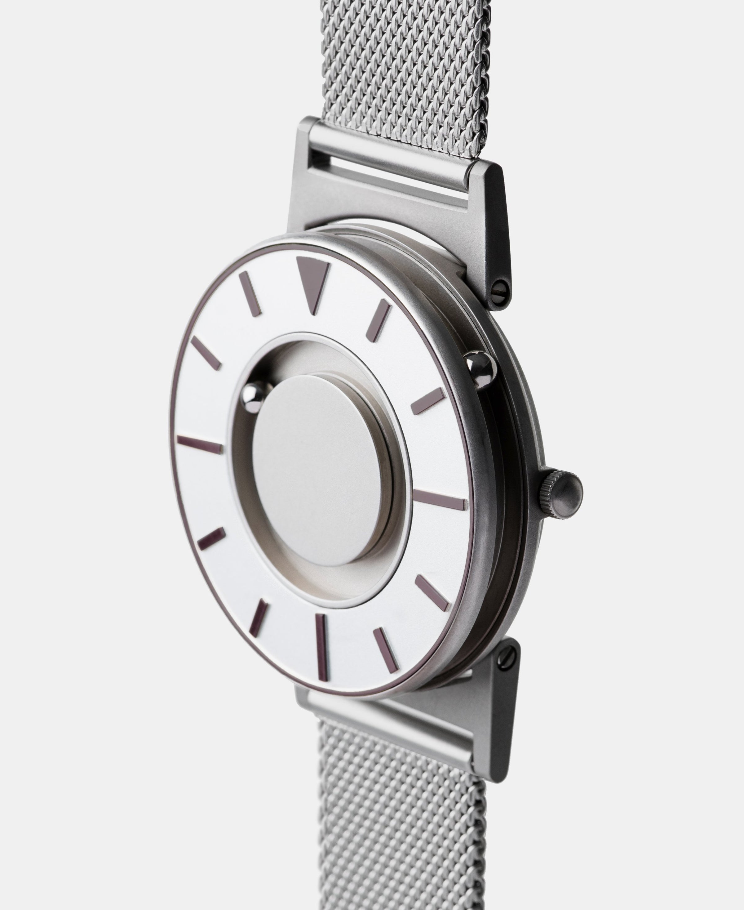 A photo of the watch from a side angle. The recessed track around the outside of the watch face is shown with the hour ball bearing in the track. The raised markers are noticeable from this perspective.