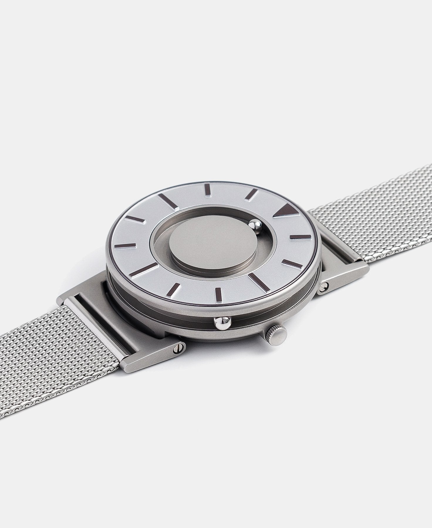 Load image into Gallery viewer, A photo of the watch lying flat on a surface. The recessed track around the outside of the watch face is shown with the hour ball bearing in the track. The raised markers are noticeable from this perspective.