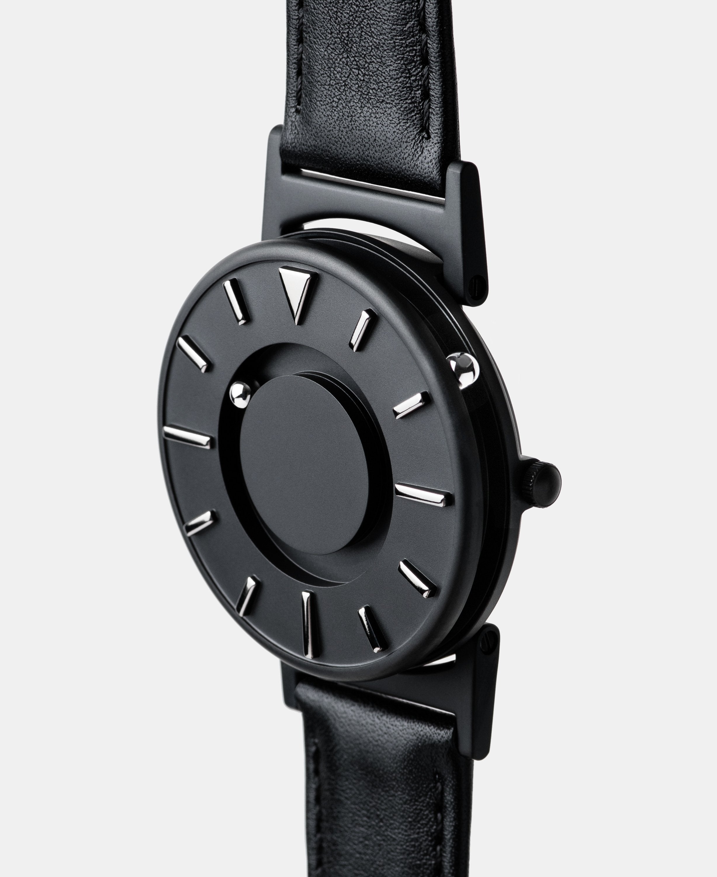 A photo of the watch from a side angle. The recessed track around the outside of the watch face is shown with the hour ball bearing in the track. The raised markers are noticeable from this perspective.