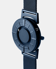 A photo of the watch from a side angle. The recessed track around the outside of the watch face is shown with the hour ball bearing in the track. The raised markers are noticeable from this perspective.
