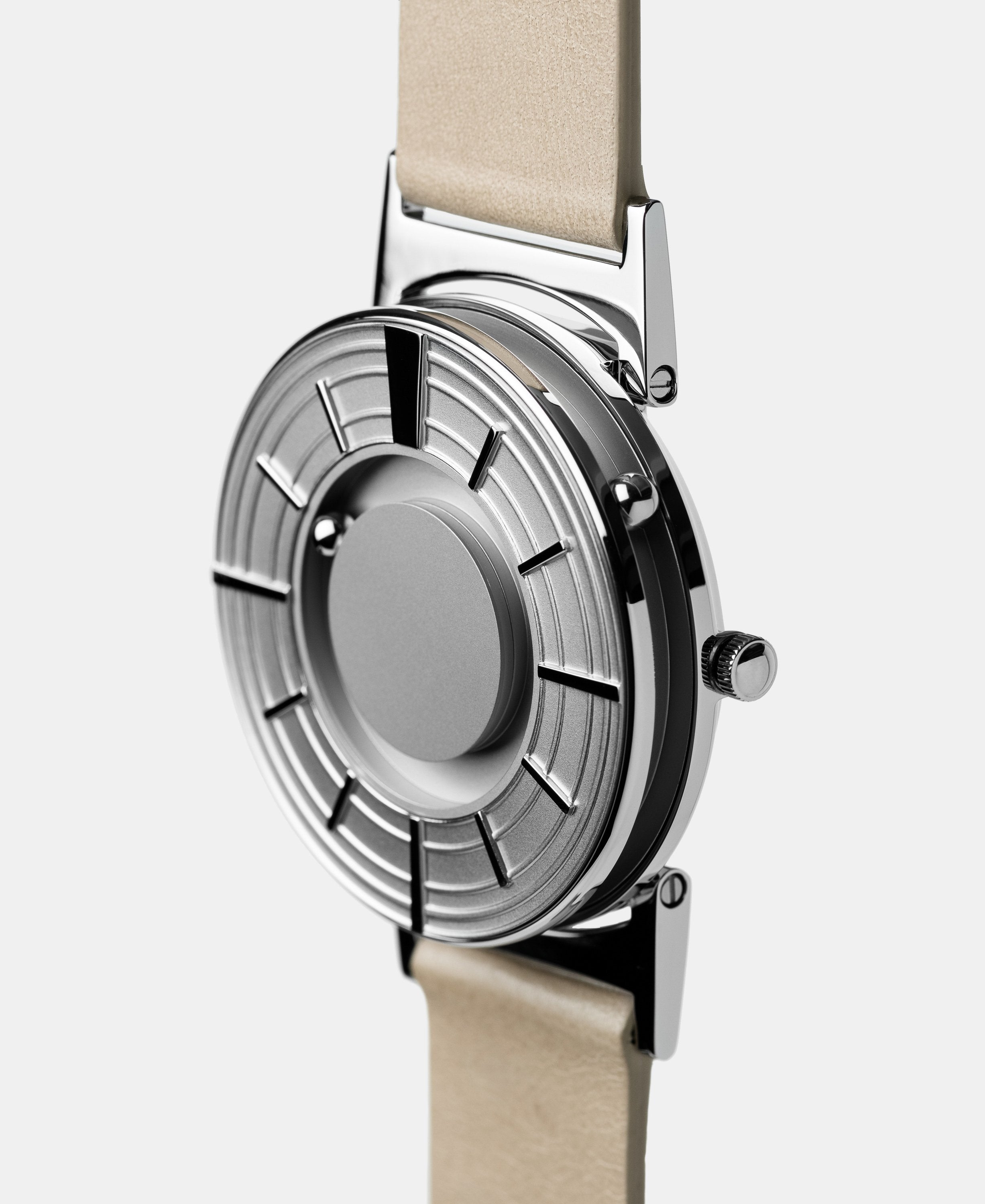 A photo of the watch from a side angle. The recessed track around the outside of the watch face is shown with the hour ball bearing in the track. The raised markers are noticeable from this perspective.
