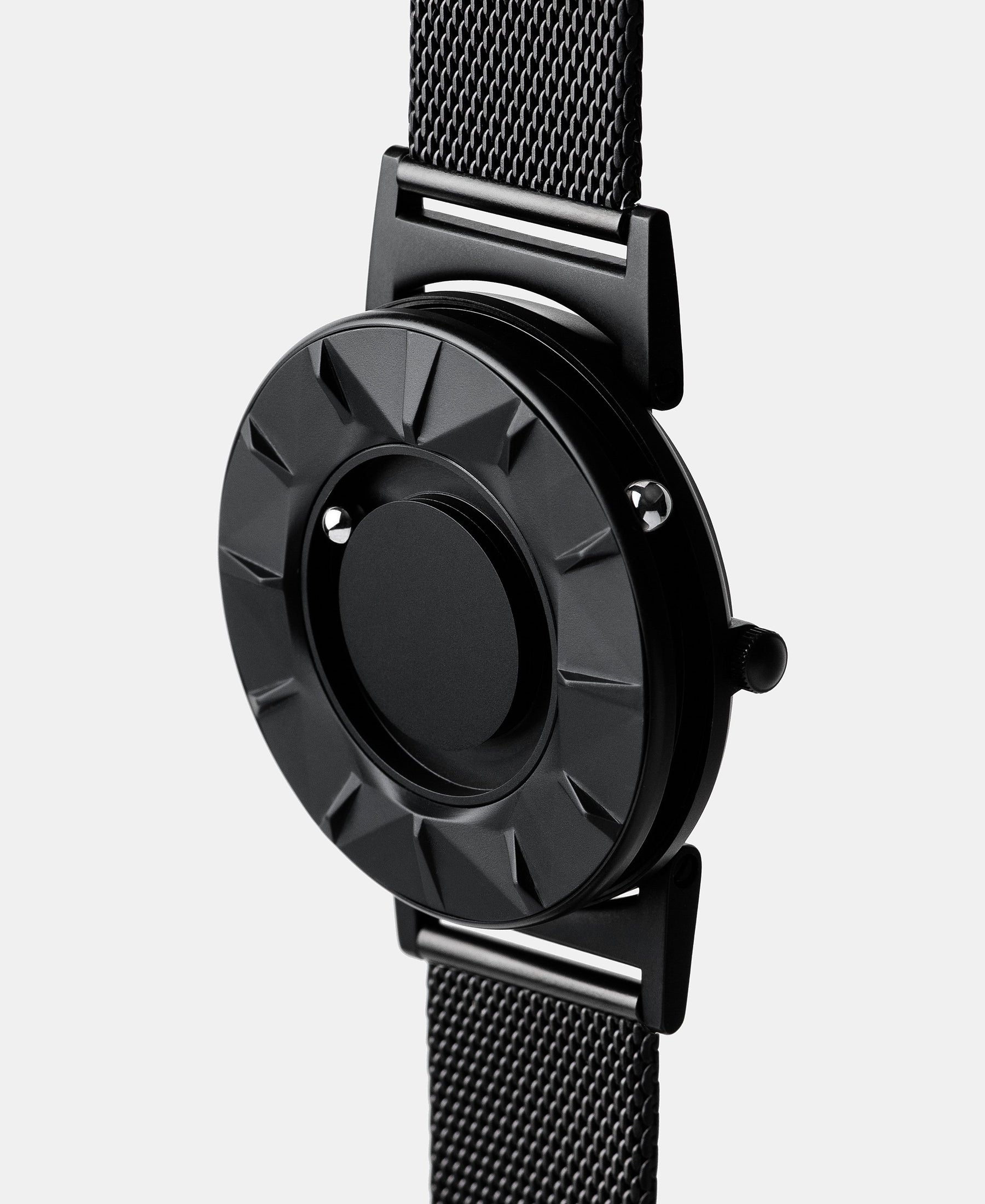 Load image into Gallery viewer, A photo of the watch from a side angle. The recessed track around the outside of the watch face is shown with the hour ball bearing in the track. The raised markers are noticeable from this perspective.