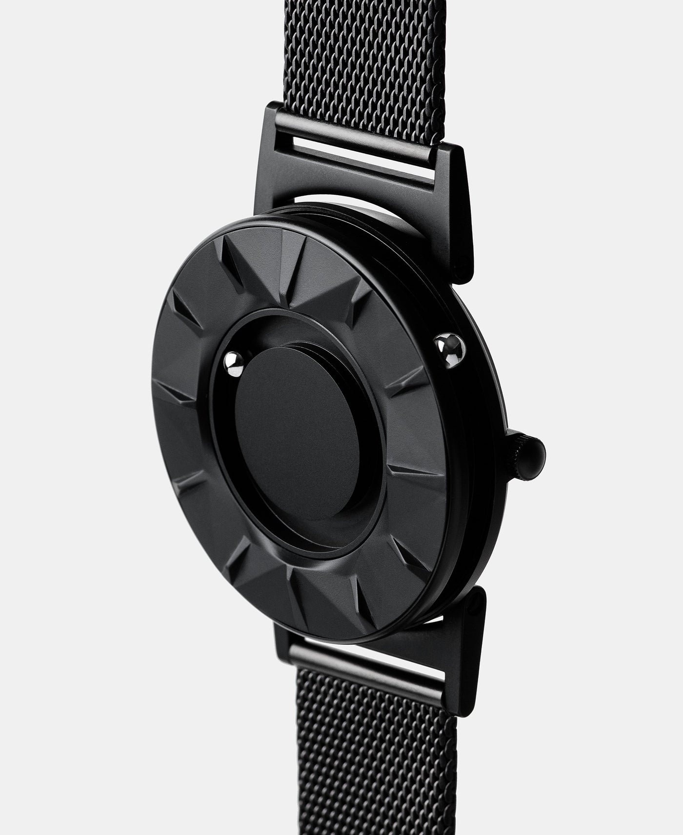 A photo of the watch from a side angle. The recessed track around the outside of the watch face is shown with the hour ball bearing in the track. The raised markers are noticeable from this perspective.