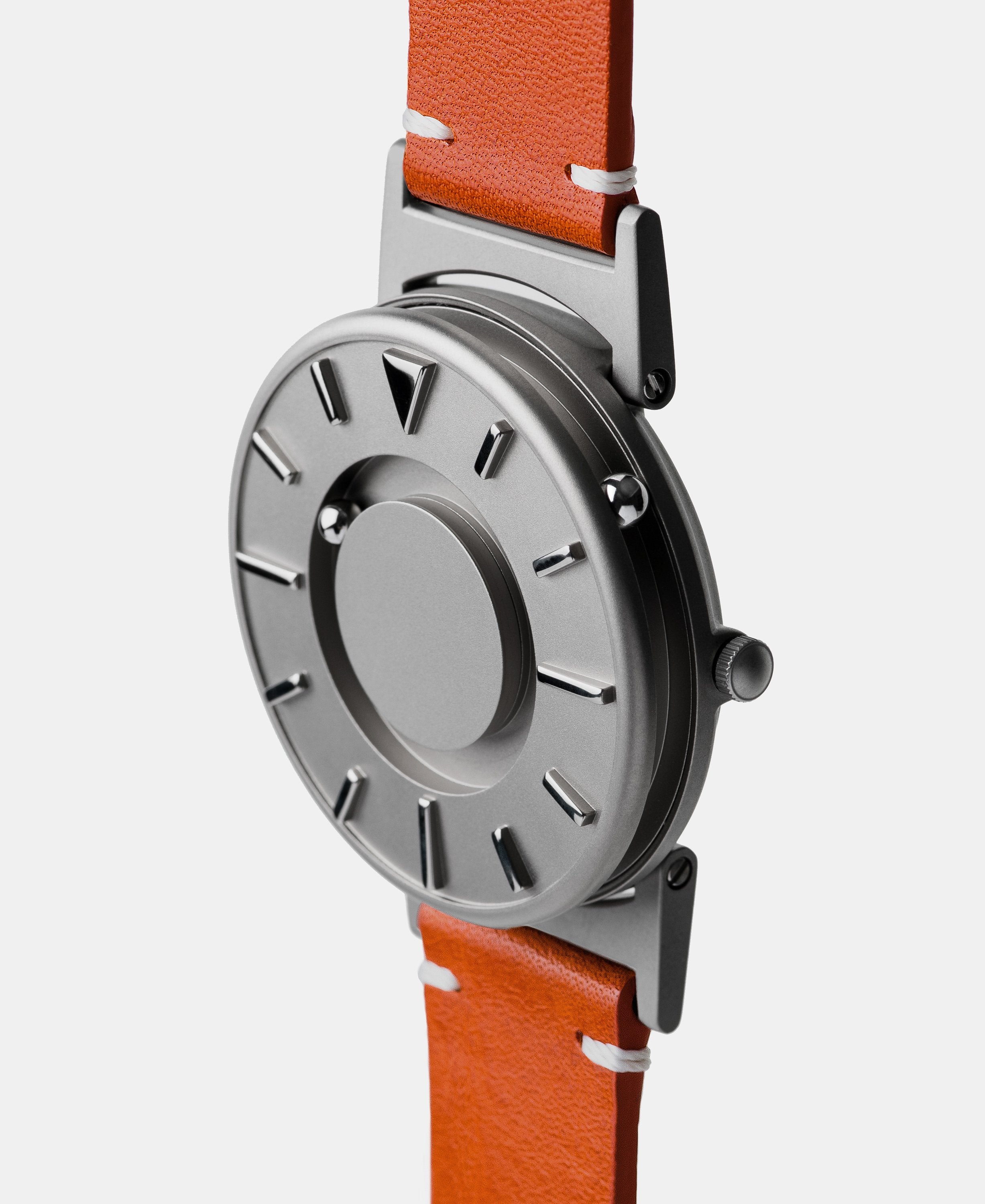 A photo of the watch from a side angle. The recessed track around the outside of the watch face is shown with the hour ball bearing in the track. The raised markers are noticeable from this perspective.