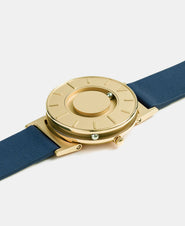 A photo of the watch lying flat on a surface. The recessed track around the outside of the watch face is shown with the hour ball bearing in the track. The raised markers are noticeable from this perspective.