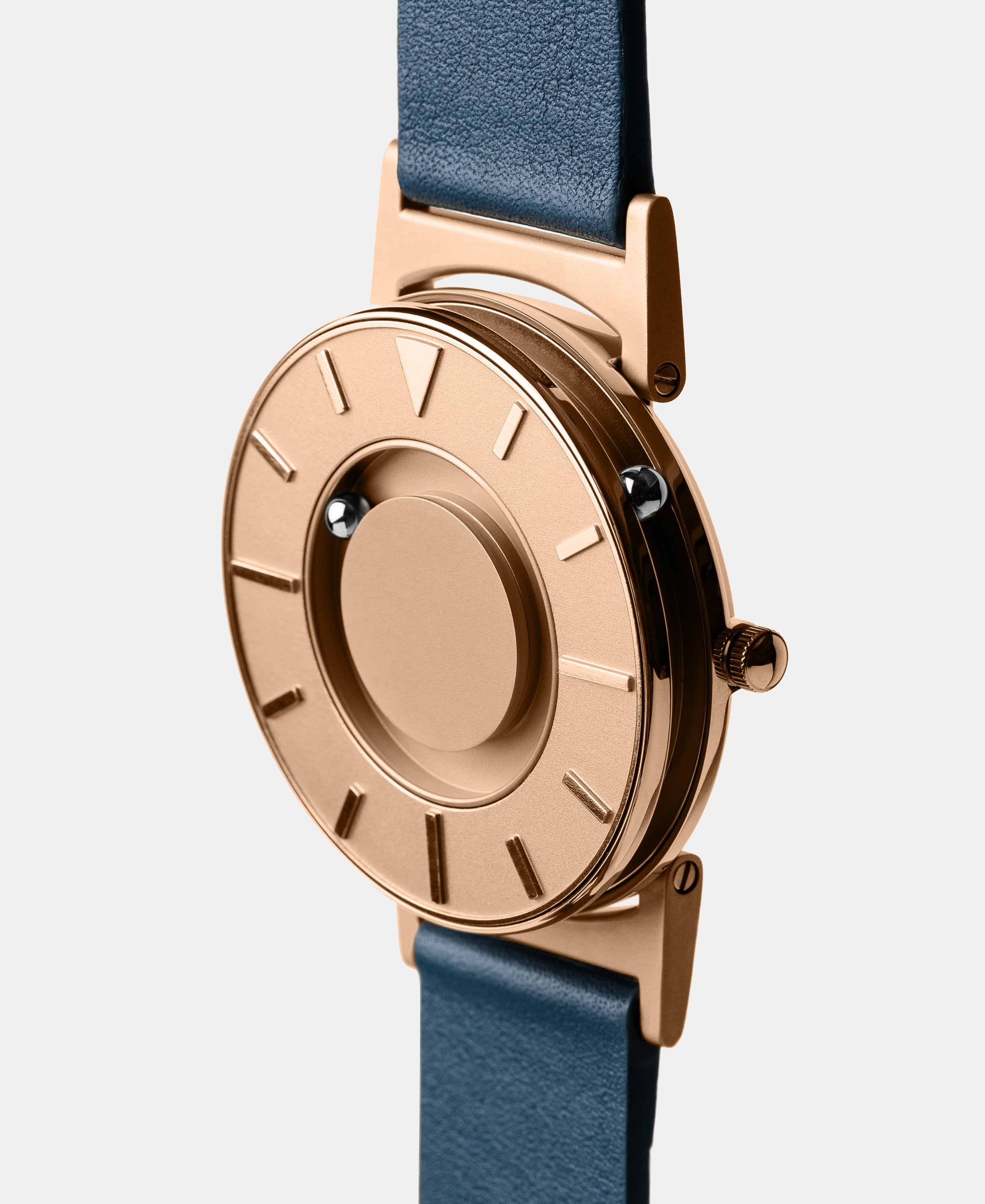 A photo of the watch from a side angle. The recessed track around the outside of the watch face is shown with the hour ball bearing in the track. The raised markers are noticeable from this perspective.