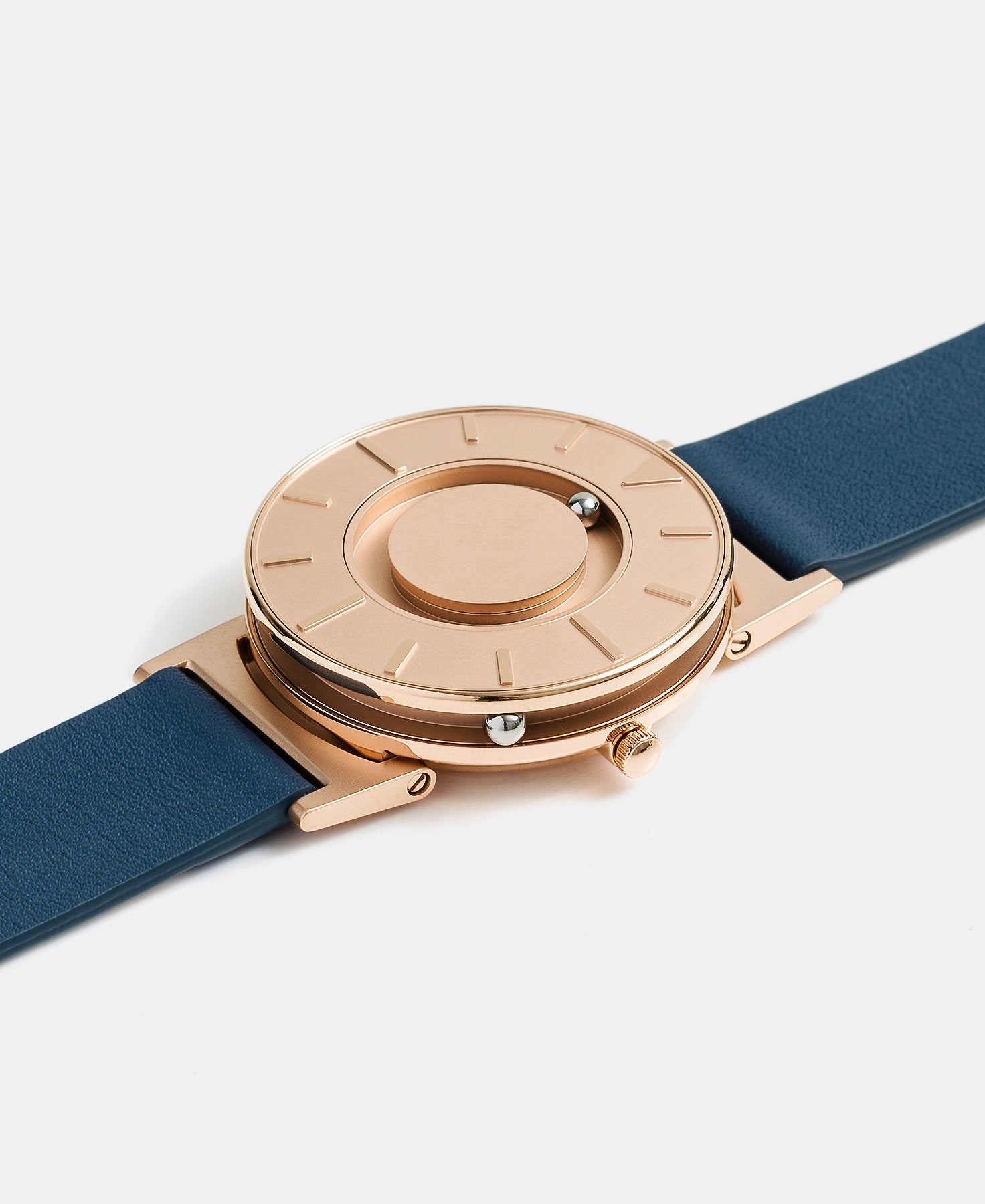 Load image into Gallery viewer, A photo of the watch lying flat on a surface. The recessed track around the outside of the watch face is shown with the hour ball bearing in the track. The raised markers are noticeable from this perspective.