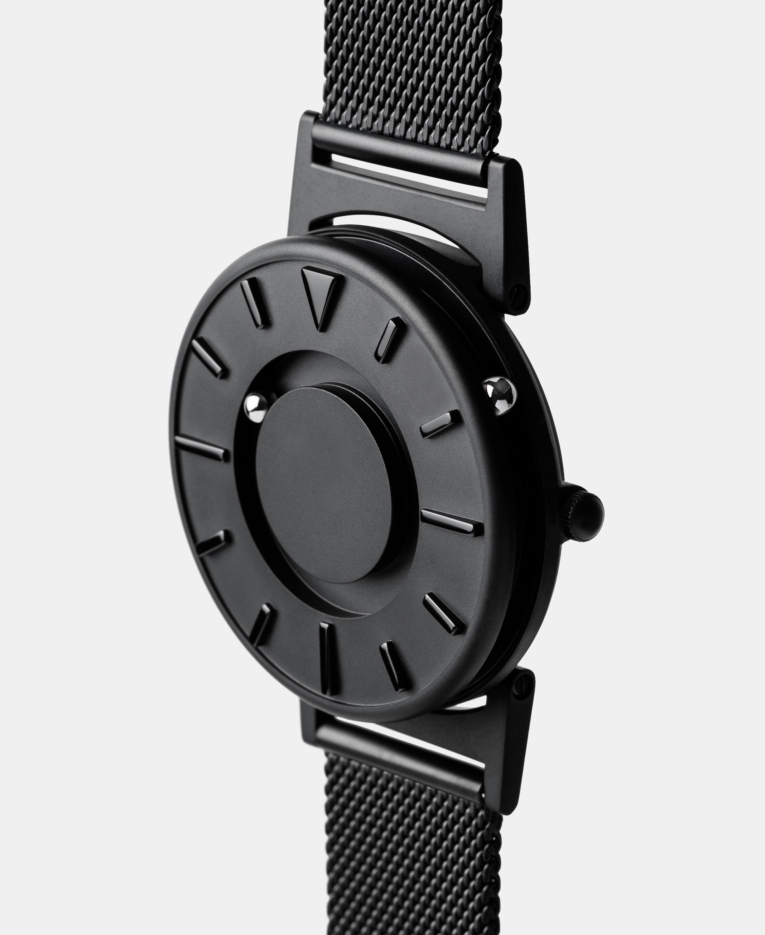 A photo of the watch from a side angle. The recessed track around the outside of the watch face is shown with the hour ball bearing in the track. The raised markers are noticeable from this perspective.
