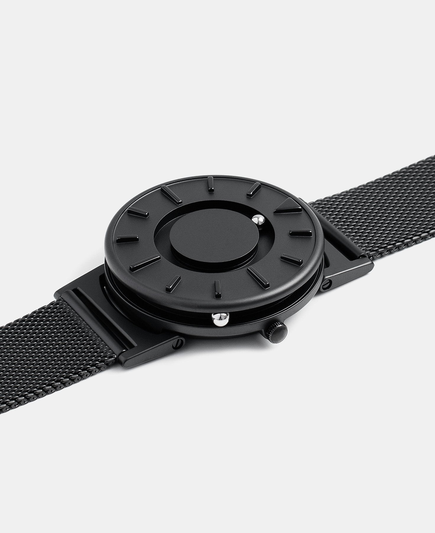 Load image into Gallery viewer, A photo of the watch lying flat on a surface. The recessed track around the outside of the watch face is shown with the hour ball bearing in the track. The raised markers are noticeable from this perspective.
