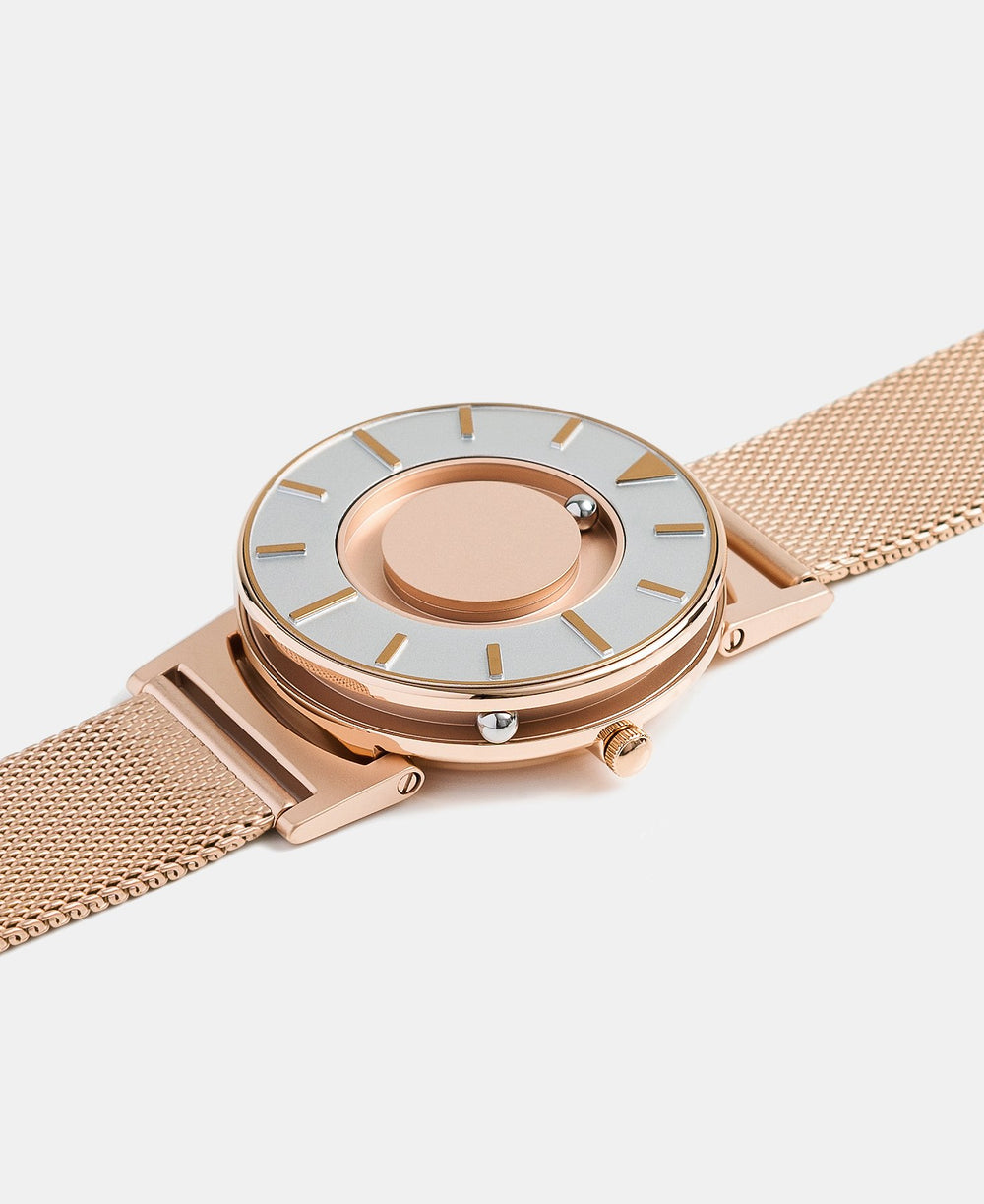 A photo of the watch lying flat on a surface. The recessed track around the outside of the watch face is shown with the hour ball bearing in the track. The raised markers are noticeable from this perspective.