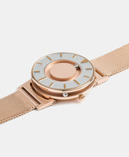 A photo of the watch lying flat on a surface. The recessed track around the outside of the watch face is shown with the hour ball bearing in the track. The raised markers are noticeable from this perspective.