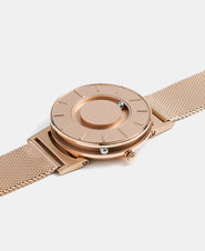 A photo of the watch lying flat on a surface. The recessed track around the outside of the watch face is shown with the hour ball bearing in the track. The raised markers are noticeable from this perspective.