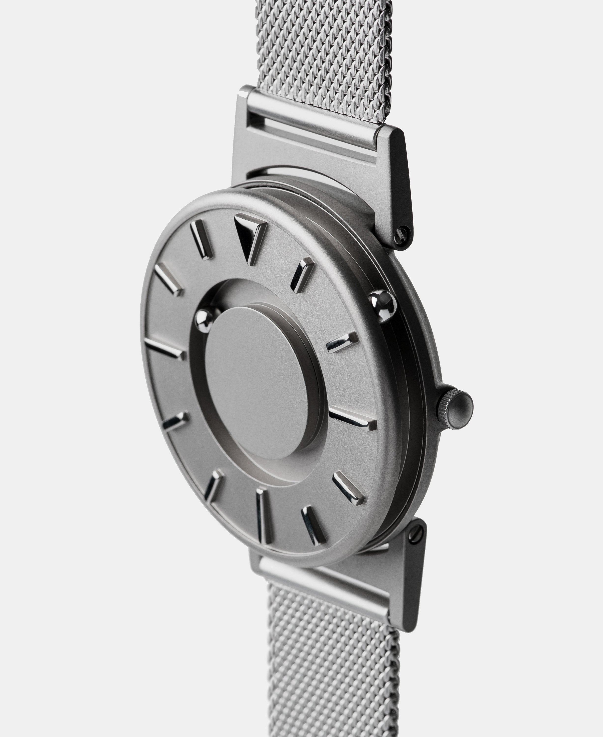 A photo of the watch from a side angle. The recessed track around the outside of the watch face is shown with the hour ball bearing in the track. The raised markers are noticeable from this perspective.