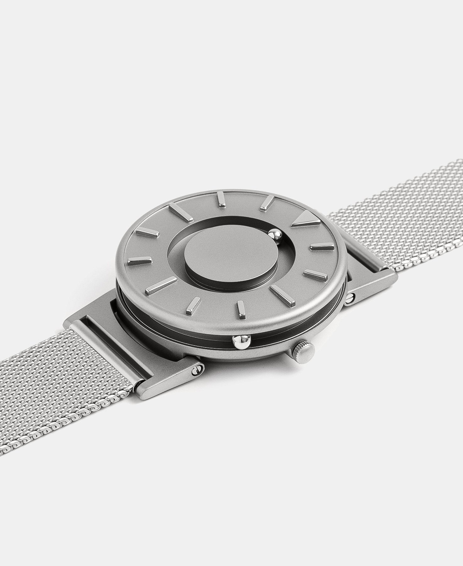 Load image into Gallery viewer, A photo of the watch lying flat on a surface. The recessed track around the outside of the watch face is shown with the hour ball bearing in the track. The raised markers are noticeable from this perspective.