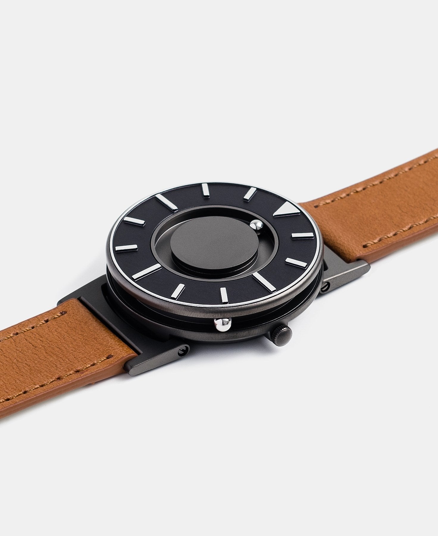 Load image into Gallery viewer, A photo of the watch lying flat on a surface. The recessed track around the outside of the watch face is shown with the hour ball bearing in the track. The raised markers are noticeable from this perspective.
