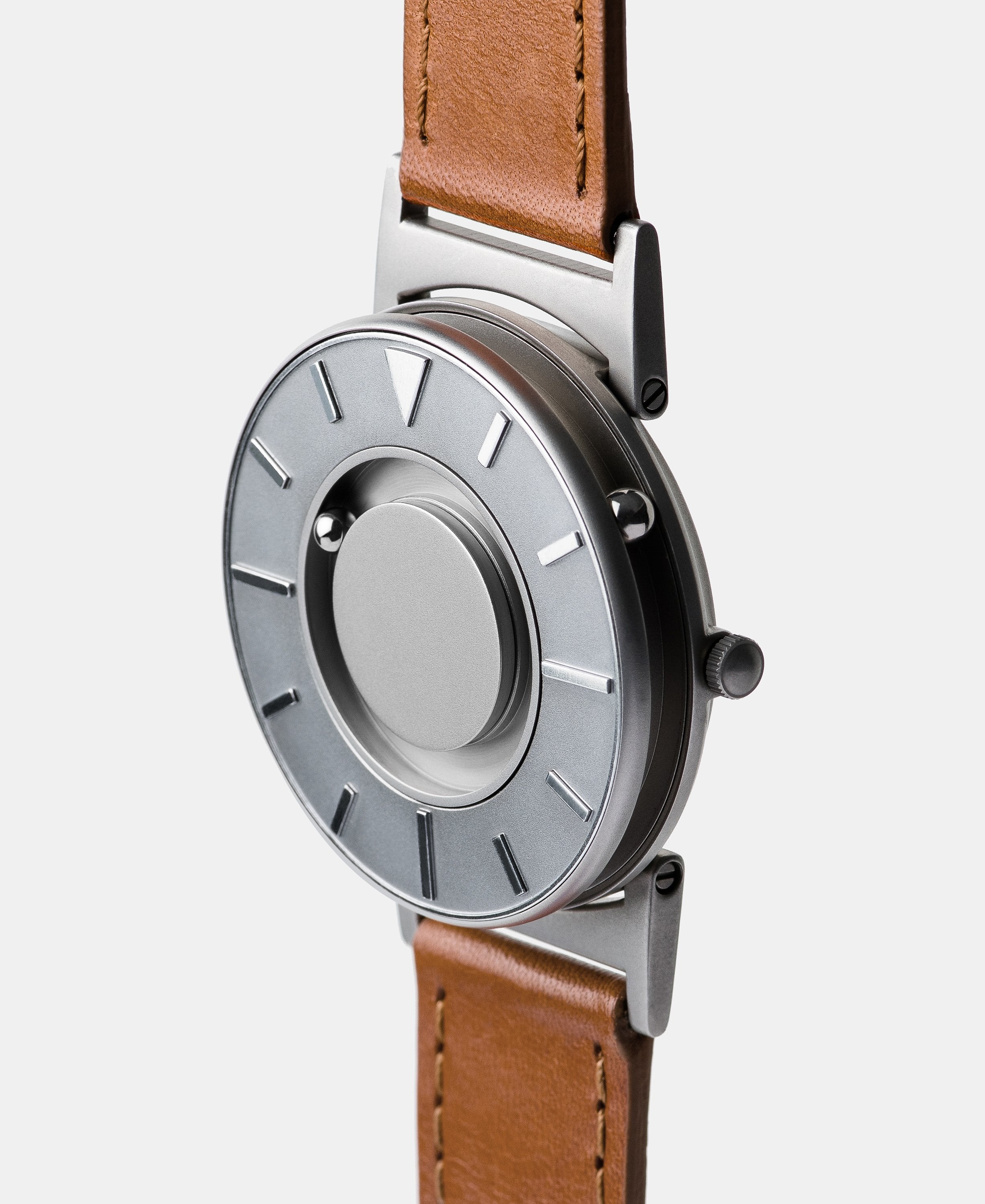 A photo of the watch from a side angle. The recessed track around the outside of the watch face is shown with the hour ball bearing in the track. The raised markers are noticeable from this perspective.